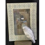 A novelty cast resin wall mirror with Iznik type tiled frame mounted by a cockatoo, 70 x 48cm