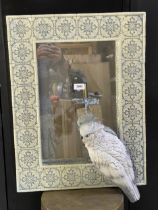A novelty cast resin wall mirror with Iznik type tiled frame mounted by a cockatoo, 70 x 48cm
