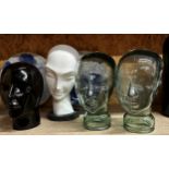 Pair of moulded glass heads possibly wig stands together with a further ceramic and plaster