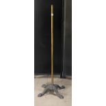 A Victorian cast iron and brass stand, the base cast with four paw feet