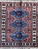 Turkish rug, three blue medallions on a washed red ground, L115 x W84cm