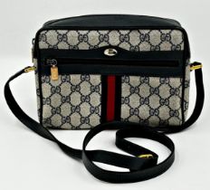 A vintage Gucci monogram GG blue red stripe crossbody bag featuring signature navy Gucci GG print