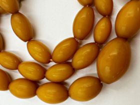 String of graduated amber or amber coloured beads, 88cm long, 95.1g gross