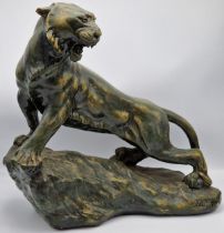 Continental plaster figure of a big cat on a rocky mount, signed H.Pilrilli, 48cm high x 51cm long