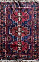 Good Afghan rug, three red medallions on a navy blue ground, L153 x W87cm