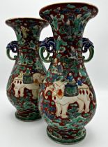 Pair of twin handled Chinese porcelain vases, enamelled in relief with elephants. 30cm high