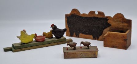 A wooden and metal pull along toy of chickens pecking grain together with a further metal stamp