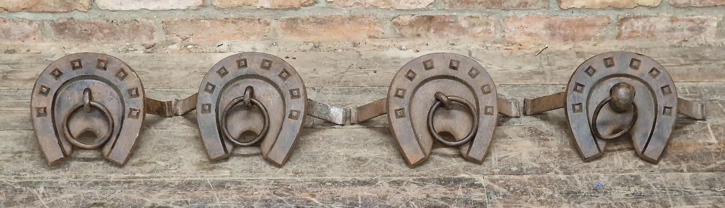 Four antique cast iron tethering rings in the form of horse shoes, H 21cm