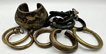 Set of five African bronze Manilla currency bangles, 6.5cm wide, together with a further large