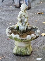 Weathered reconstituted stone shell shaped birdbath on plinth, decorated with a seated satyr playing