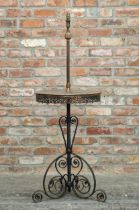 Antique wrought iron standard lamp of scrolled form, integrated table with pierced metal apron, H