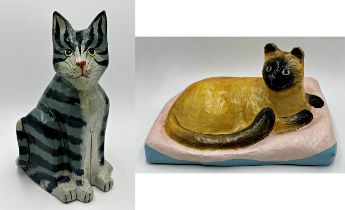 Two large papier mache cats, a Siamese on a cushion, 26cm H x 41cm W, and a seated tabby 37cm