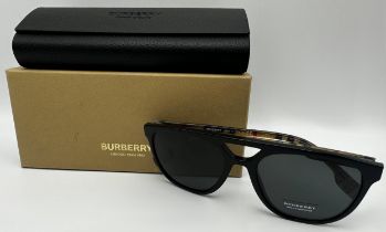 A pair of Burberry men's sunglasses with black frames and Burberry chequered temples. In unused