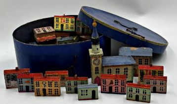 A collection of folk art painted wooden houses and buildings, the largest 19cm x 12cm (a large