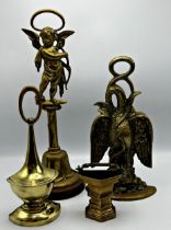 Three antique brass door porters, to include eagle with snake and a cherub, with a further brass