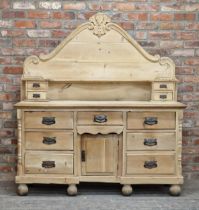 Victorian pine dresser with shaped back fitted with an arrangement of eleven drawers and central
