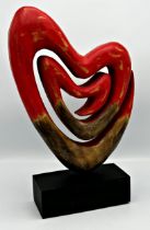 20th Century school- stylised carved wooden heart upon a plinth base 42cm high