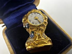 Unusual 18ct charm pendant, in the form of a clock with enamel dial and gilt hands, compass to the