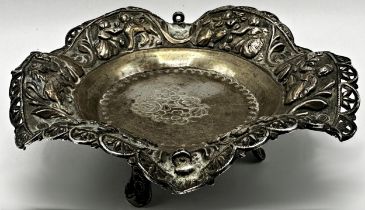 Good Indian silver pedestal dish, rim embossed with figures, raised on three feet, signature to