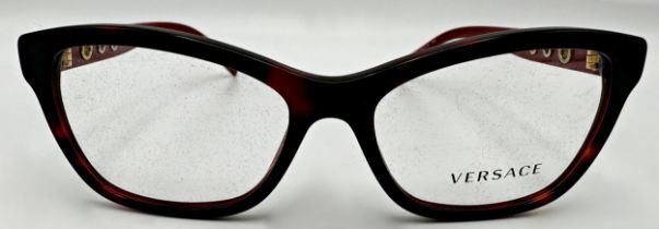 A pair of Versace woman's Bordeaux rectangle eyeglasses with red frame and branded temples. Model