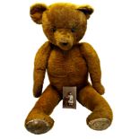 Large vintage straw stuffed bear with articulated limbs and leather pads, 90cm high, with original