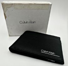A black leather wallet by Calvin Klein. Measures 13cm x 10cm with presentation box.