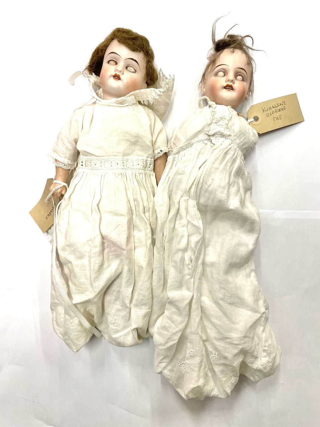 A pair of Gebruder Kuhnlenz bisque head dolls, to include: - An open-mouthed with blue eyed,