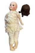 SFBJ bisque head doll. Black eyes and brown hair, in floral petticoat and bloomers. Marked to back