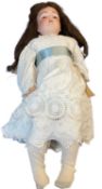 Kestner bisque head doll in white dress with turquoise sash. Blue eyes and brown hair. Marked to