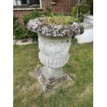 A pair of composite garden urns with square bases
