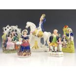 A group of five 19th Century Staffordshire pottery and porcelain figures, to include lovers under an