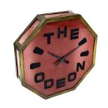 An Art Deco brass and red glass Odeon cinema wall clock, octagonal glazed form, the face etched