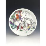 A Chinese circular plate, famille rose decorated with two figures on a balcony observing an