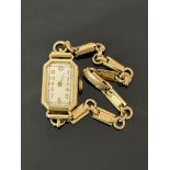 A lady's gold cased watch with octagonal dial, (glass and hand missing) on a 9ct gold fancy link