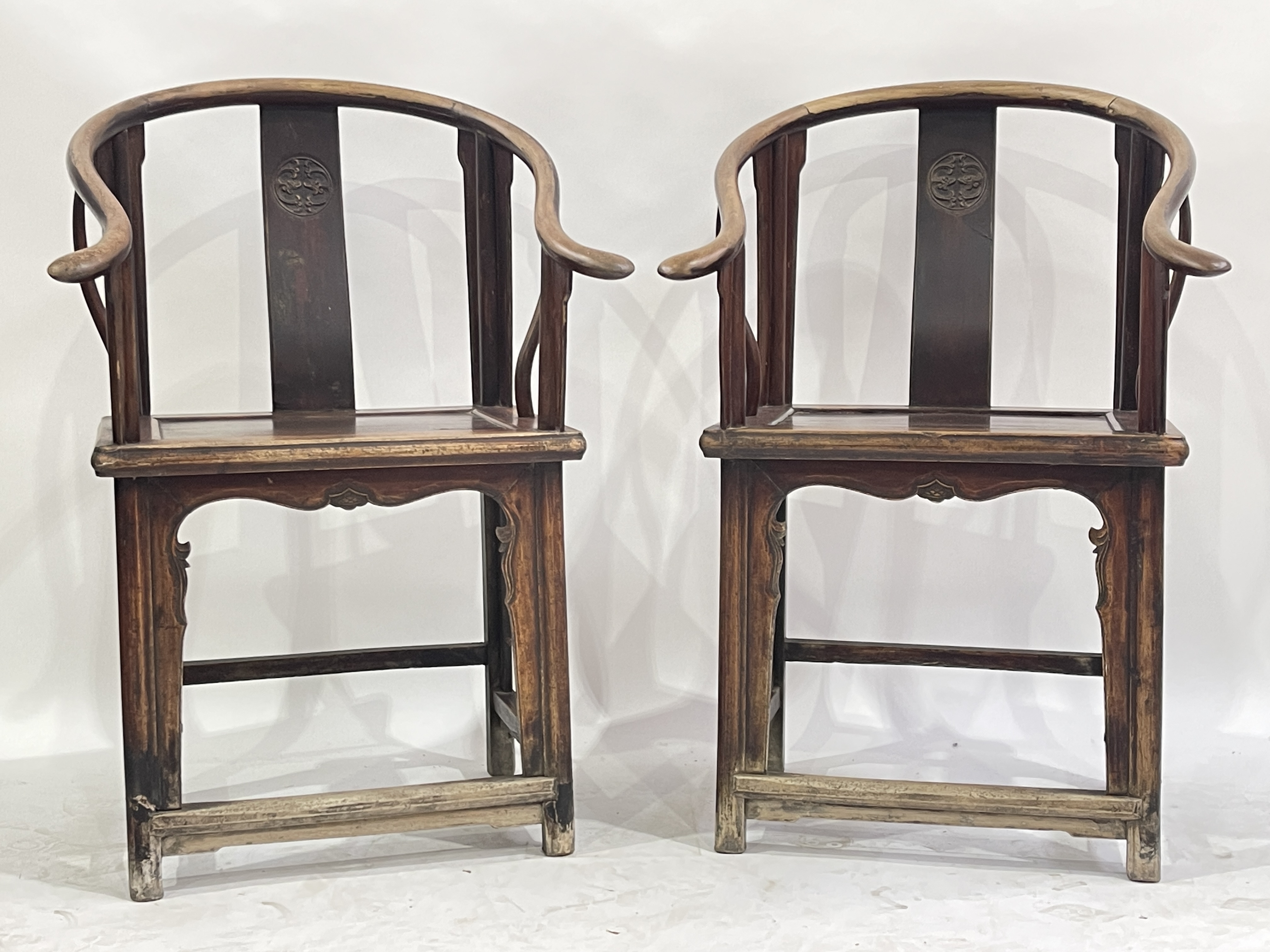 A pair of Chinese horseshoe-back wooden armchairs, North China, late Qing Dynasty, curved and
