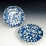 A pair of Chinese blue & white dished plates, wavy rims, decorated with vases of foliage and