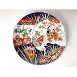 A Japanese imari charger, painted with Geisha girls, trees, flowers and birds within the body of a