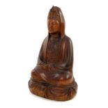 A Chinese carved treen Buddha, Qing dynasty, the serene robed deity seated cross legged with