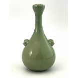 A Chinese green celadon glaze bottle vase, moulded foliate opening, beast mask and ring handles,