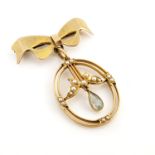 A 9ct gold bow brooch with oval gold pendant, pearl set leaves with topaz drop