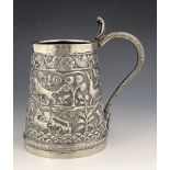 A large Indian white metal tankard or mug, circa 1900, conical form, repousse embossed and