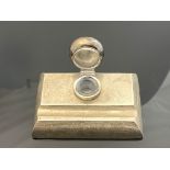 An Edwardian silver inkwell with pen recess, London 1906, rectangular slab form, hinged domed lid,