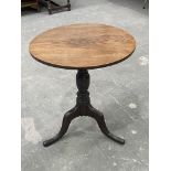 A George III country oak tripod table, circa 1820, circular tilt top, baluster turned support,