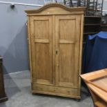 A 19th century pine wardrobe, fitted two panelled doors over single drawer on bun feet, 197cm high x