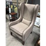 A contemporary tweed upholstered gentleman’s wing back armchair