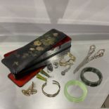 A Japanned lacquer glove box containing various costume jewellery, including jade bangles, glove