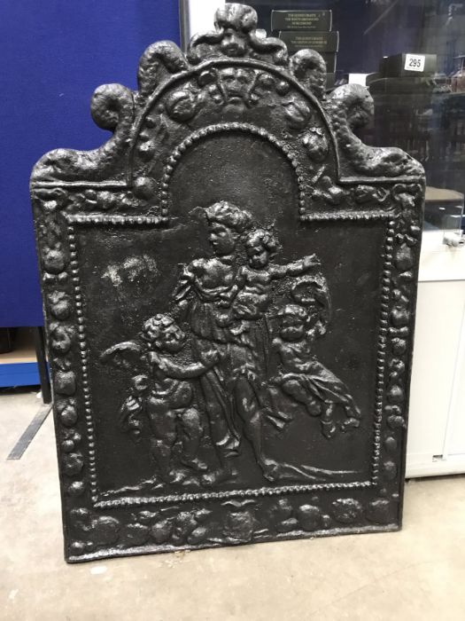 A cast iron fire back, arch form, relief cast with classical figures and putti, within fruiting