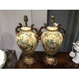 A pair of urn form floral painted table lamps, gilt foliate twin handles, 46cm including fitting