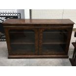 A Victorian walnut veneered glazed side cabinet, moulded top and shelved interior on stepped