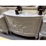 A pair of French style white painted bow front commodes/chest of drawers, moulded floral swags and
